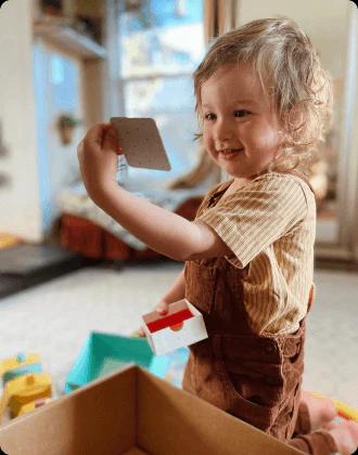 Child looking at playthings from The Investigator Play Kit